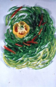 Artistic arrangement of sliced green, red, and yellow bell peppers on a white surface, forming a spiral shape with a yellow bell pepper center.